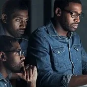Three colleagues reviewing a screen together